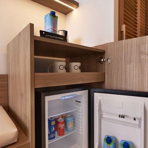 un réfrigérateur avec des boîtes de boisson coca cola et aqua