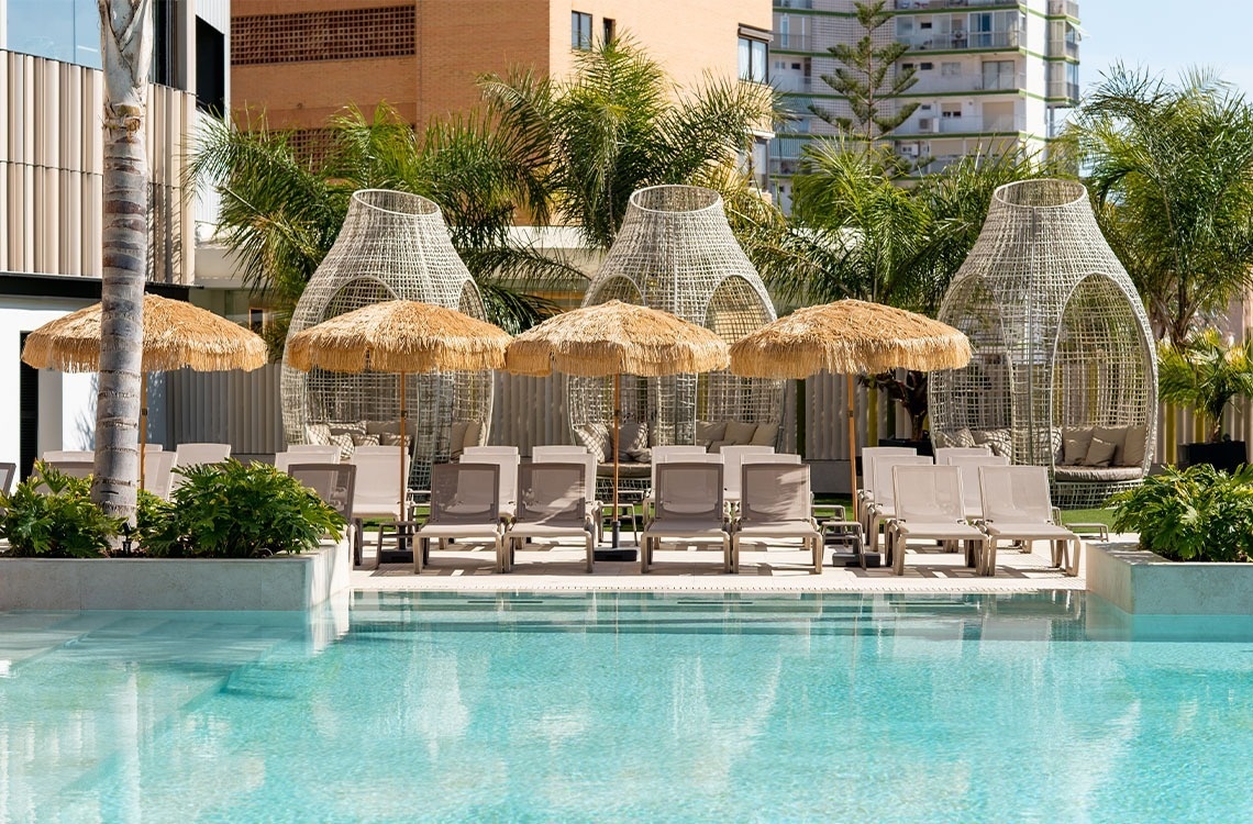un restaurante con mesas y sillas y una vista de una piscina