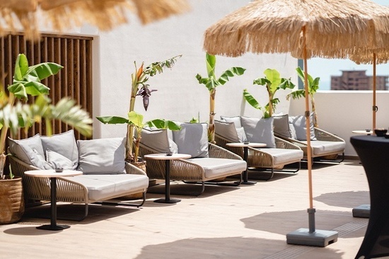 a patio with chairs and tables under umbrellas