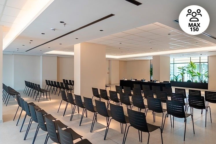 rows of black chairs are lined up in a conference room