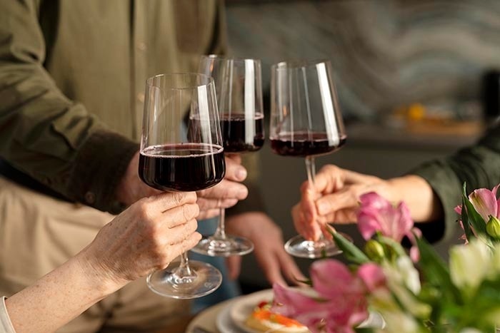 un grupo de personas están brindando con copas de vino .