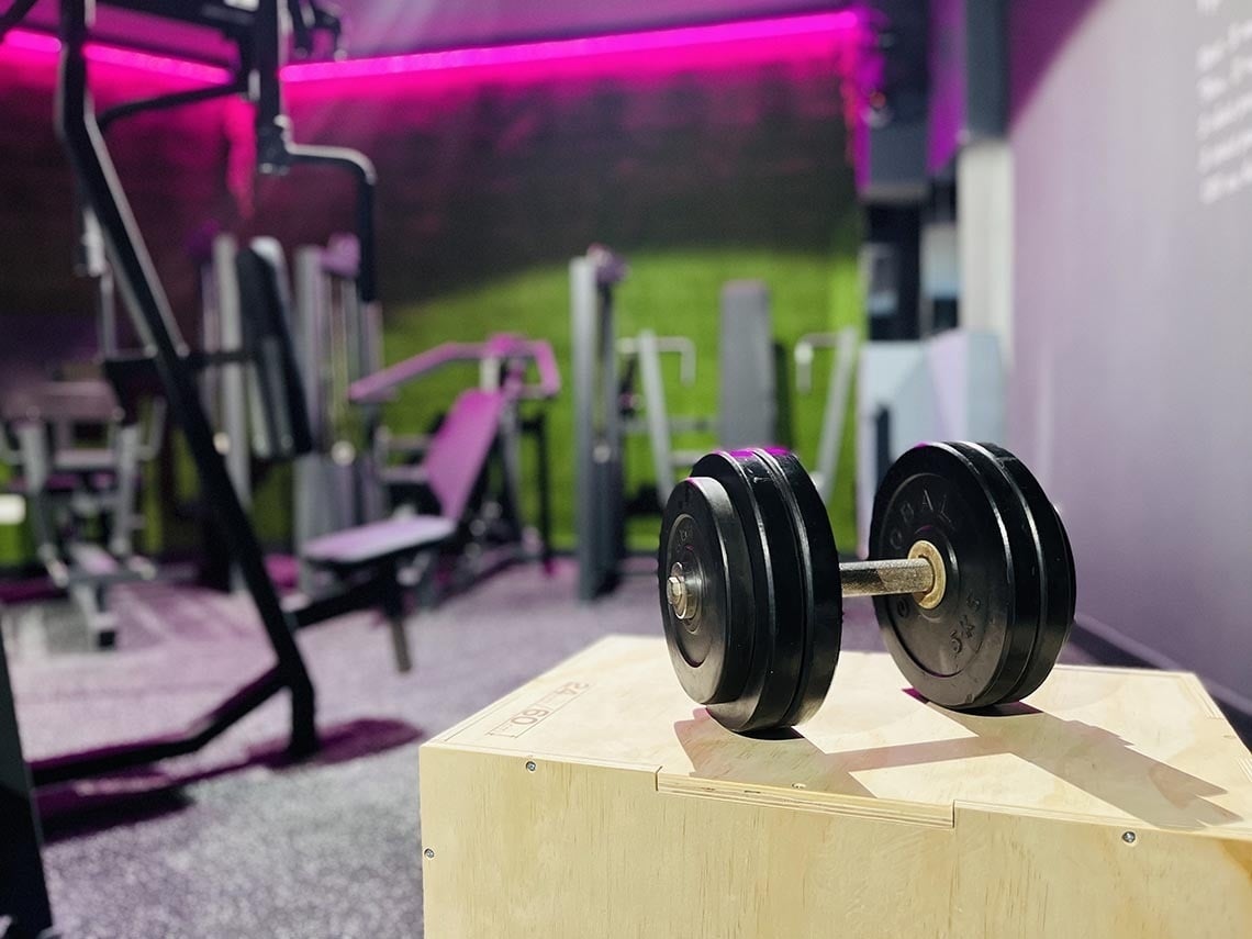 un par de mancuernas están sobre una caja de madera en un gimnasio