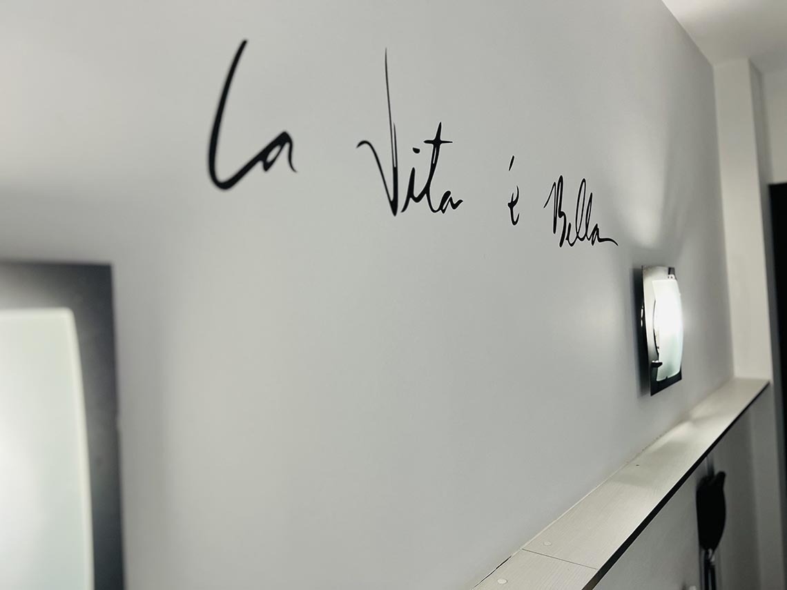 la vida e bella está escrita en una pared blanca