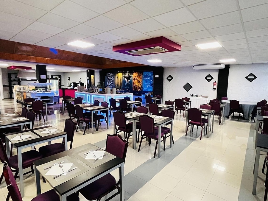 a restaurant with tables and chairs and a fire extinguisher on the wall