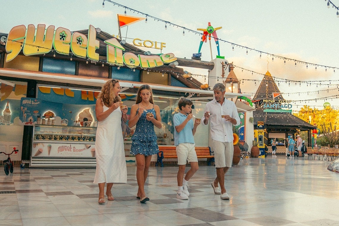 una familia come helado en un parque de diversiones