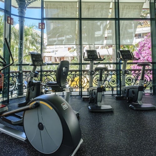 un gimnasio lleno de equipos de ejercicio y una puerta que dice extintor