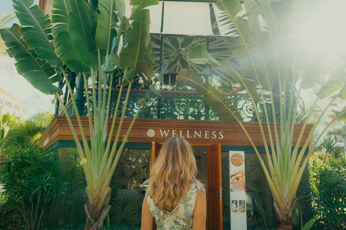 a woman stands in front of a wellness building