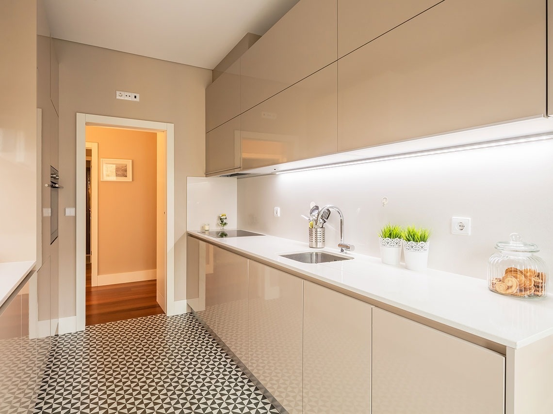 uma cozinha com pia e armários brancos