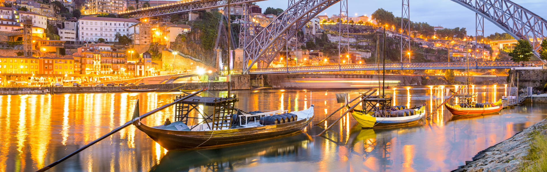 uma ponte sobre um rio com barcos ao fundo