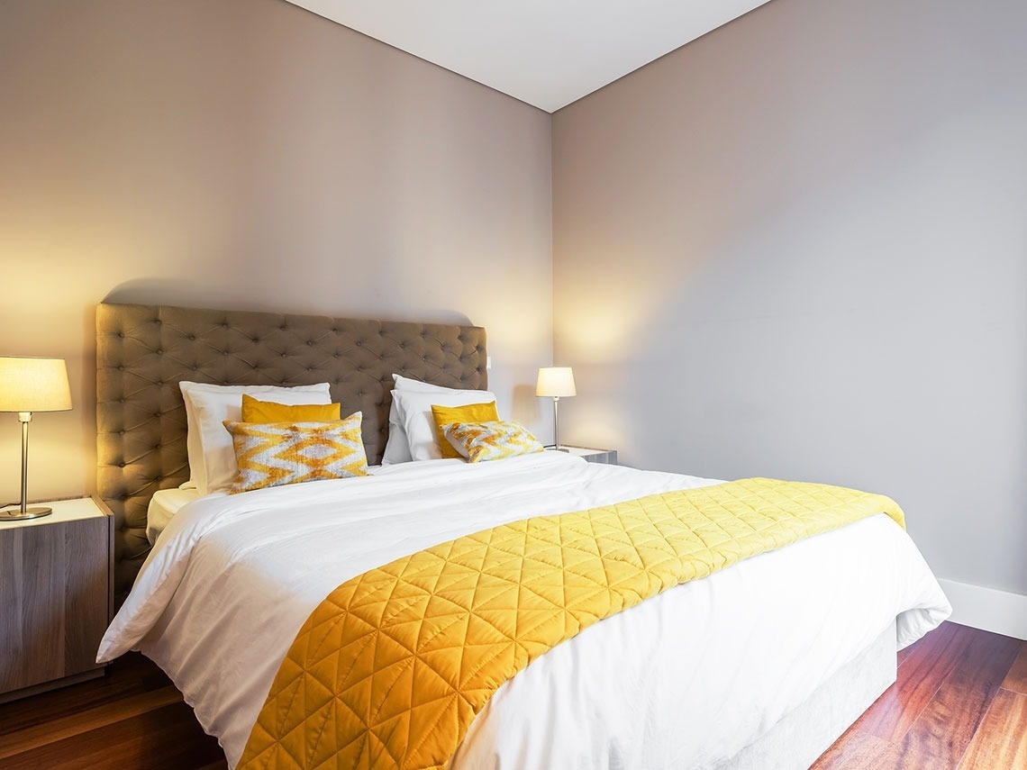 um quarto com cama king size e travesseiros amarelos