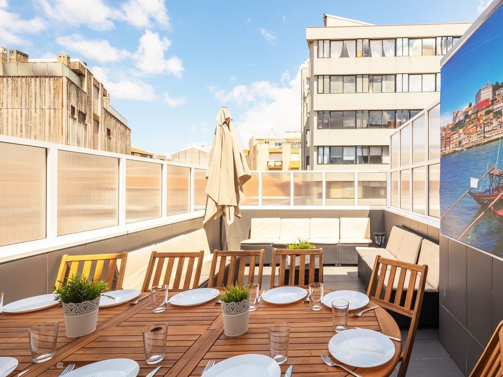 uma mesa de jantar com pratos e copos em um terraço