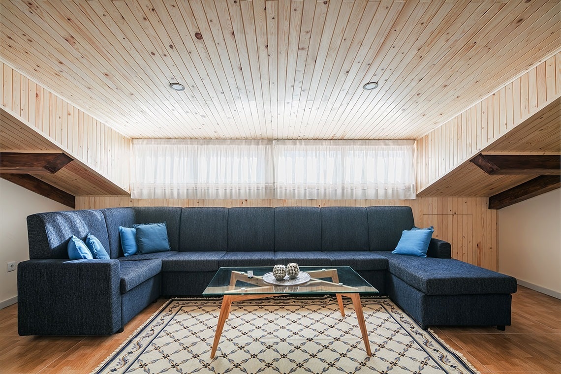 uma sala de estar com um sofá azul e uma mesa de vidro