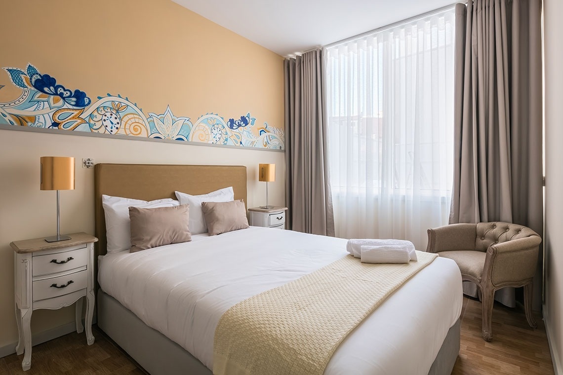 um quarto com uma cama e duas mesas de cabeceira