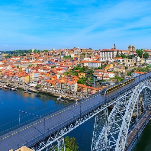 a bridge over a river with a city in the background