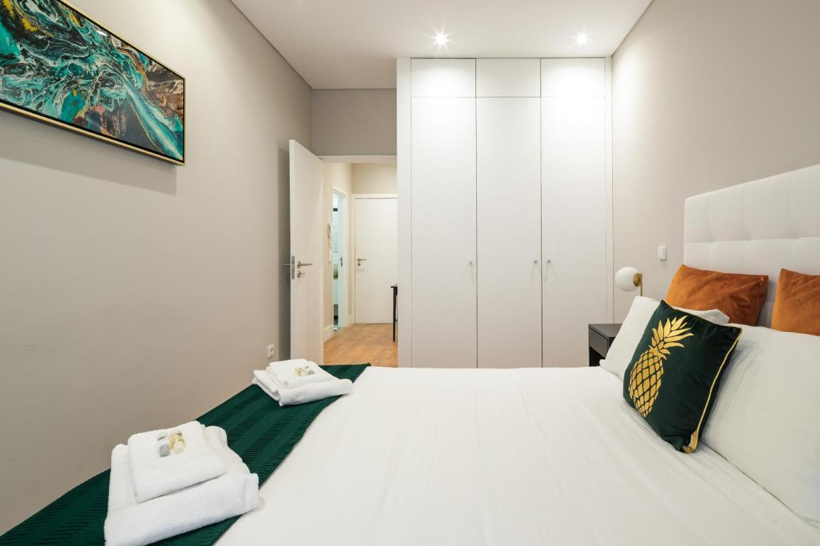 um quarto com cama , cadeiras e vasos de flores