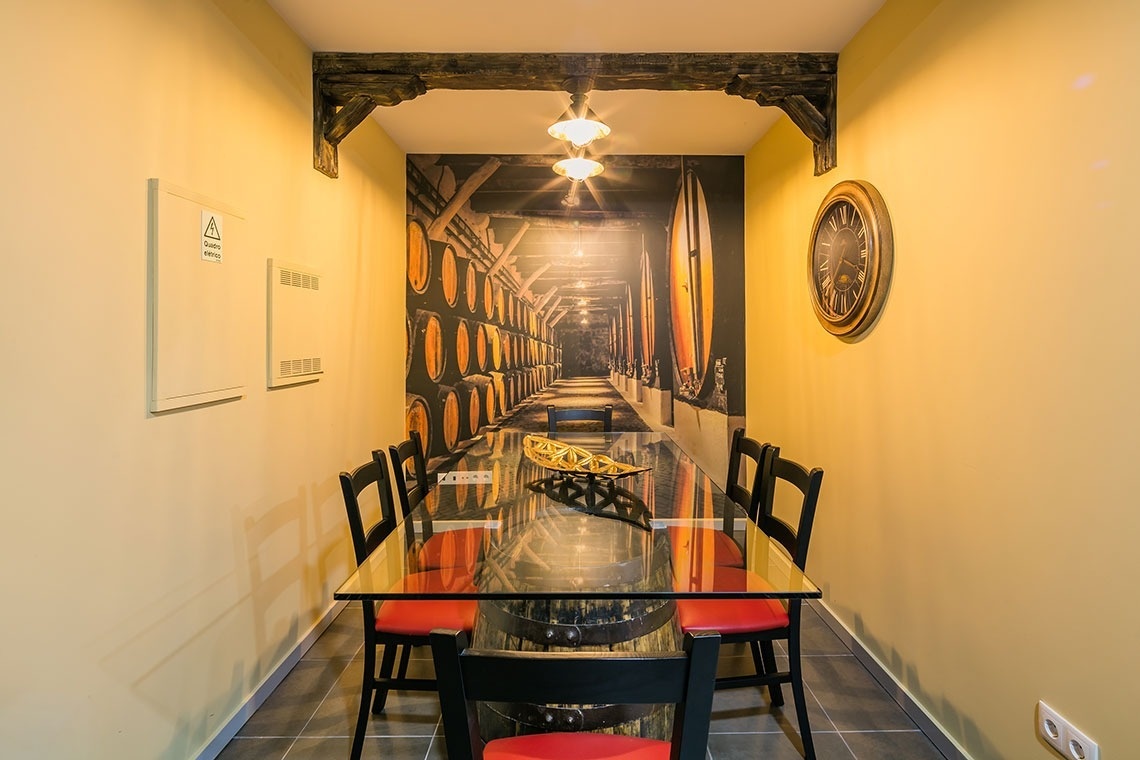 uma sala de jantar com uma mesa de vidro e cadeiras vermelhas