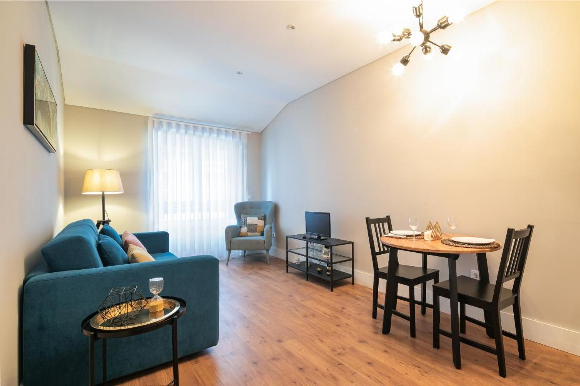 uma sala de estar com um sofá azul e uma mesa de jantar