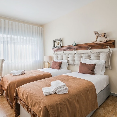 a bedroom with two twin beds and a rocking horse on the headboard