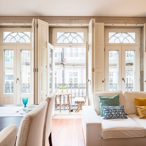 a living room with a white couch and a balcony