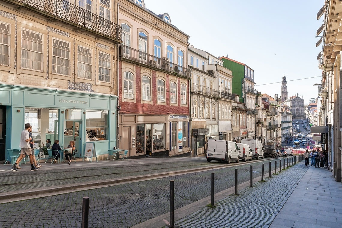 um homem caminha por uma rua cheia de lojas