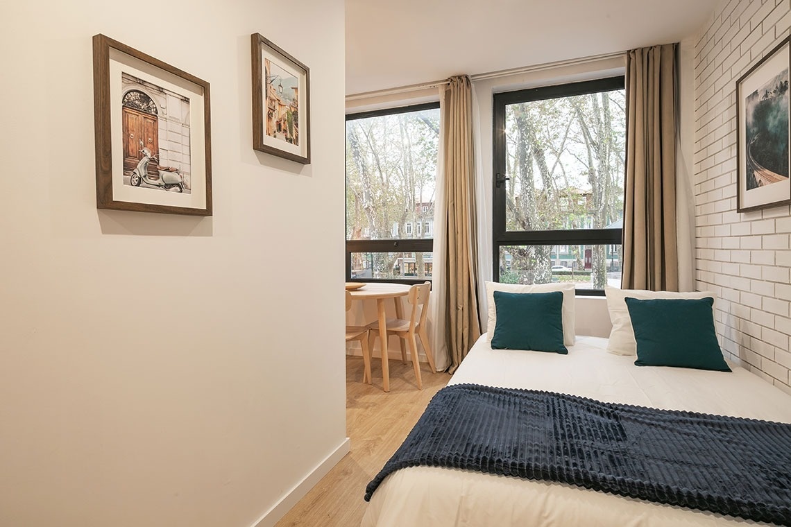 um quarto com uma cama branca e almofadas azuis