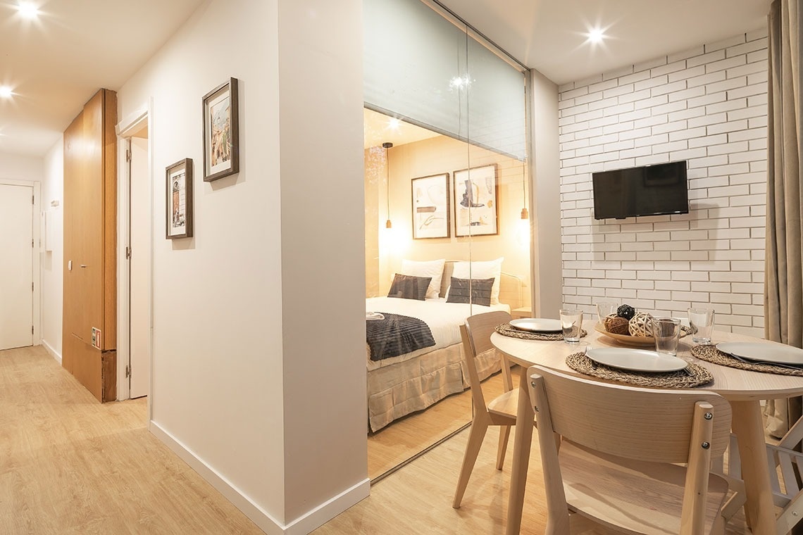 uma sala de jantar com uma mesa e cadeiras e uma cama