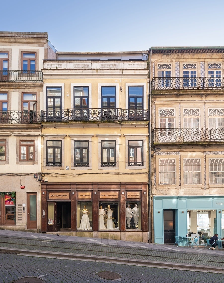 um prédio amarelo com duas lojas em frente a ele