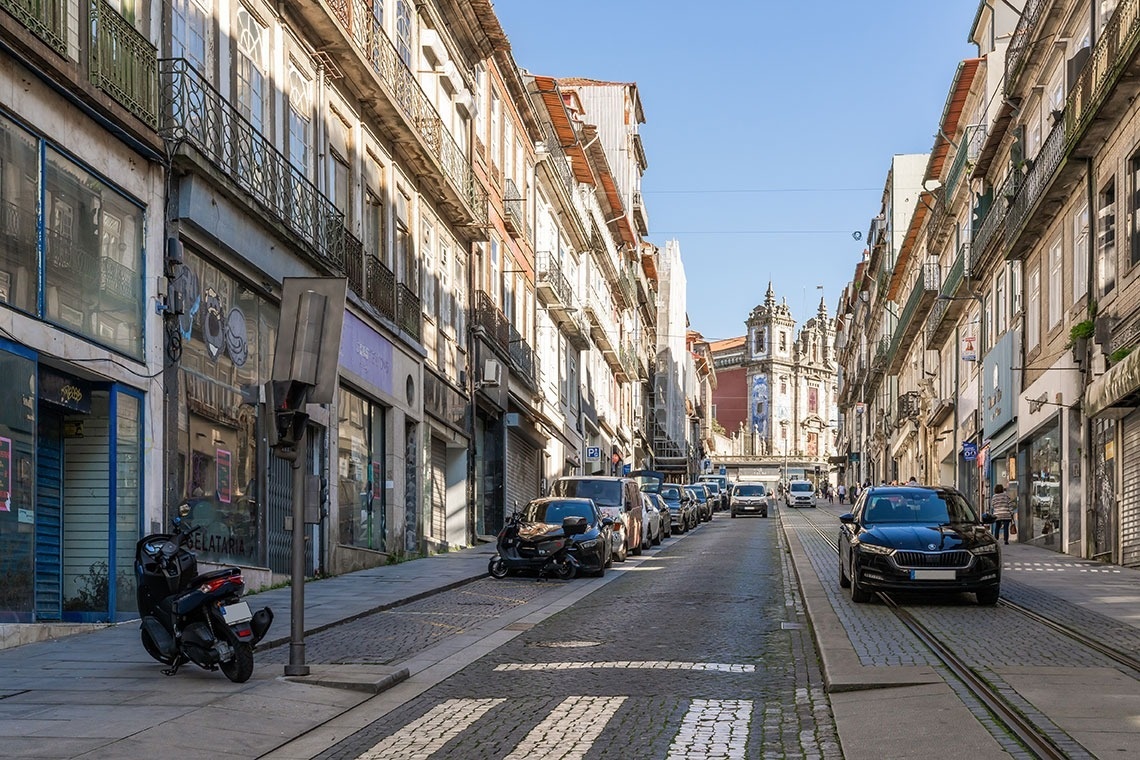 um carro azul está estacionado na rua ao lado de uma motocicleta vermelha