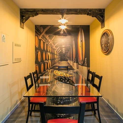 a room with a table and chairs and a clock on the wall