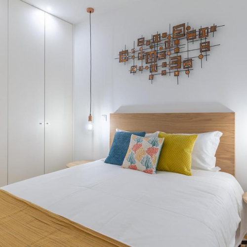 a bed with a wooden headboard and pillows on it