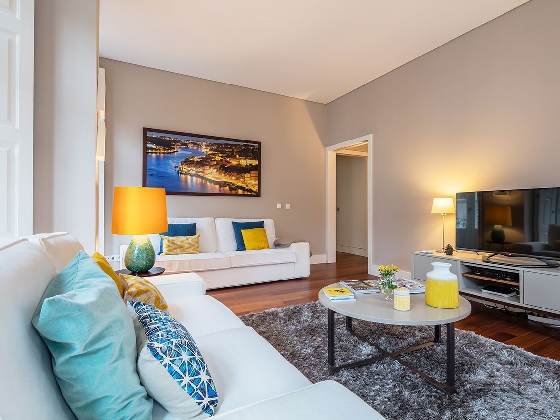 uma sala de estar com um sofá branco e uma mesa de centro