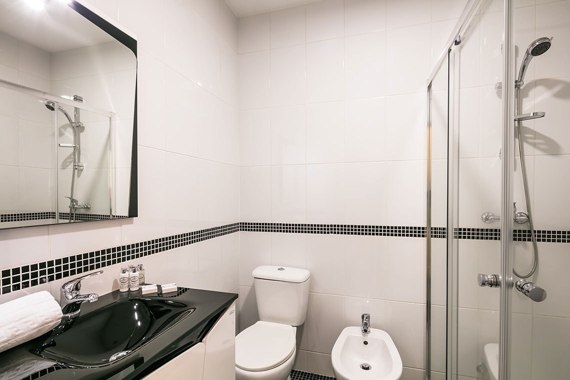 um banheiro com uma pia preta e um vaso sanitário