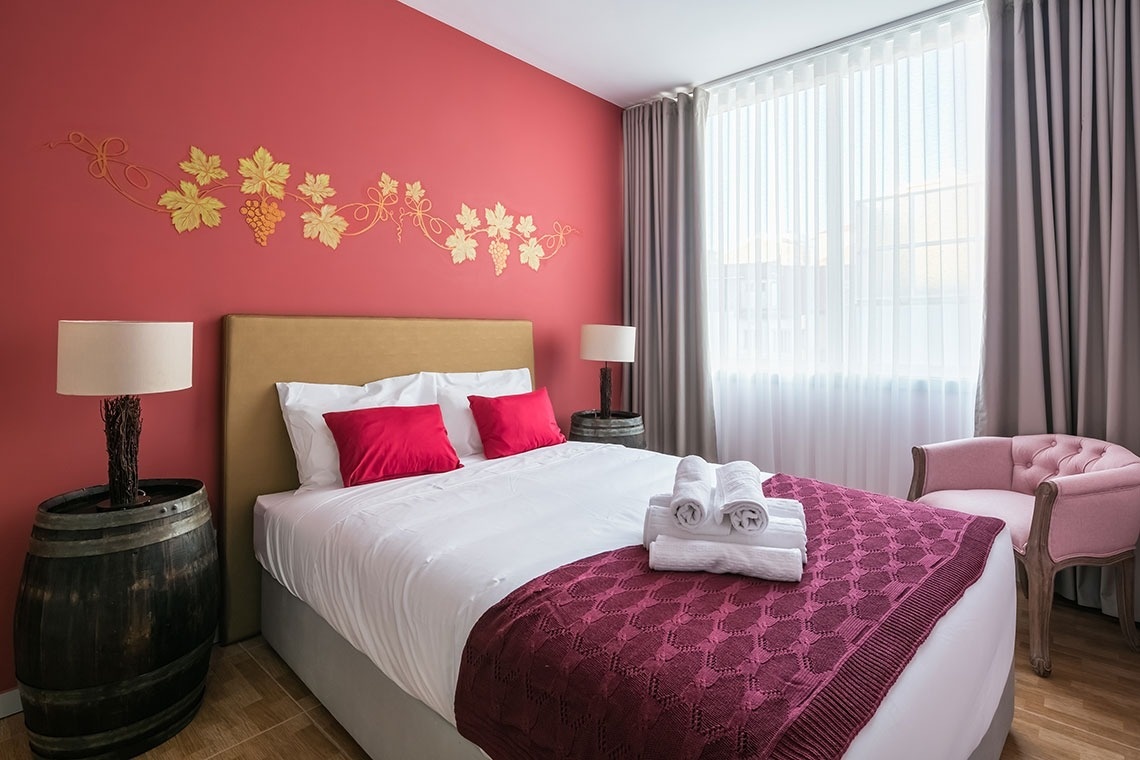 um quarto com paredes vermelhas e uma cama branca