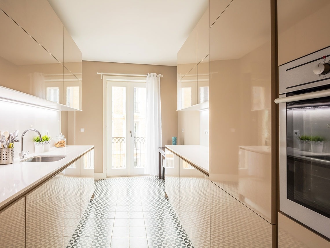 uma cozinha com armários bege e um forno branco