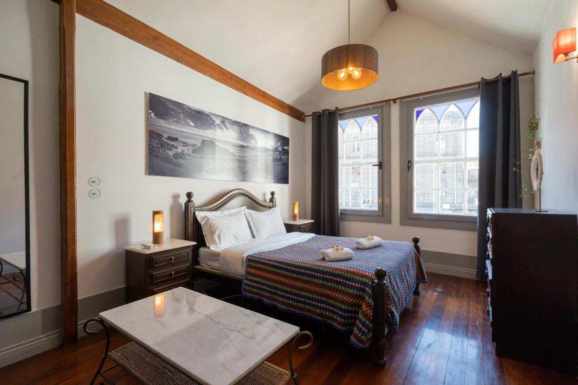 um quarto com cama , cadeiras e vasos de flores