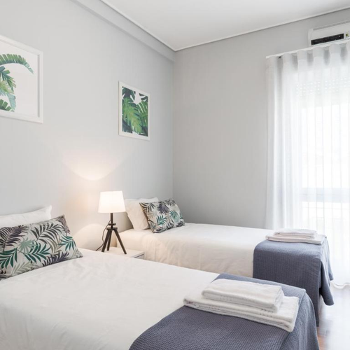 a bedroom with two beds and two pictures on the wall