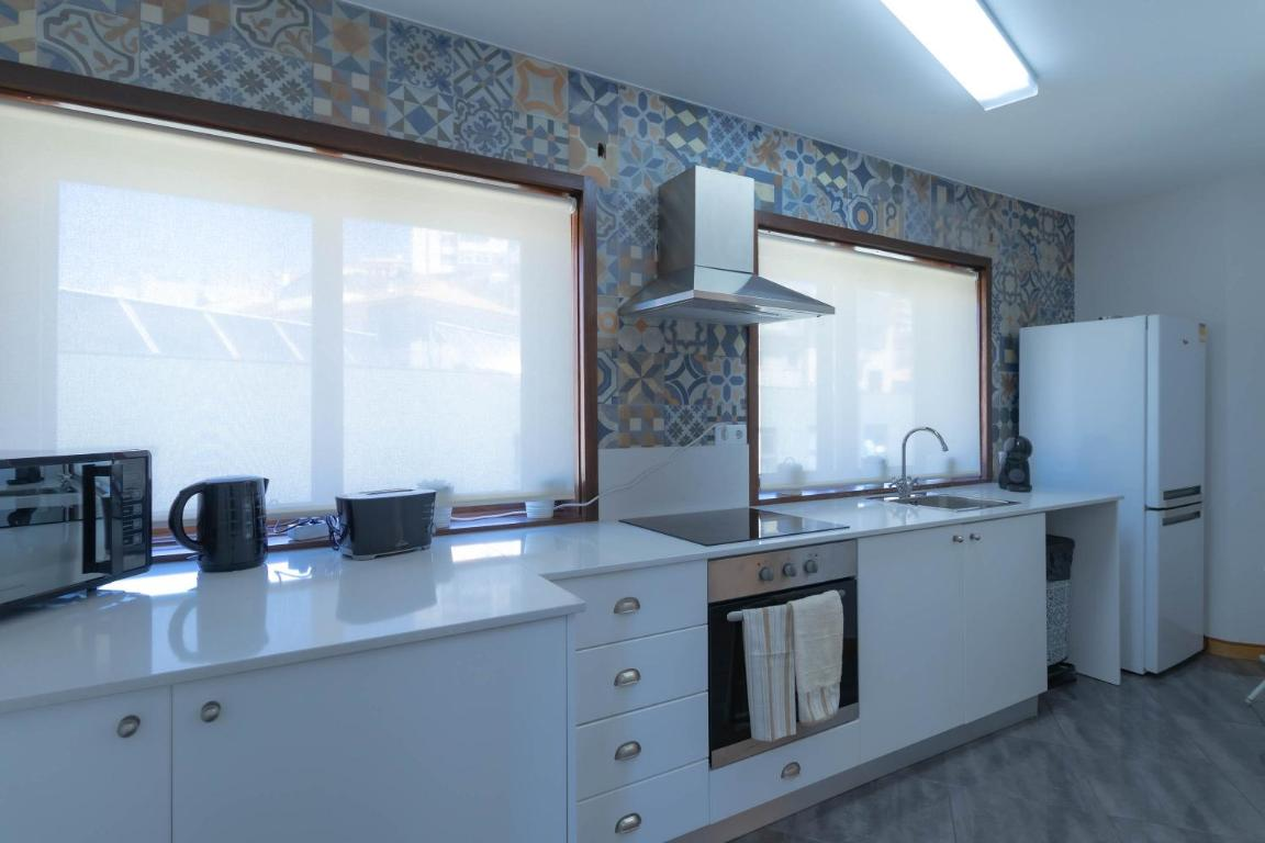 uma cozinha com utensílios brancos e uma geladeira branca