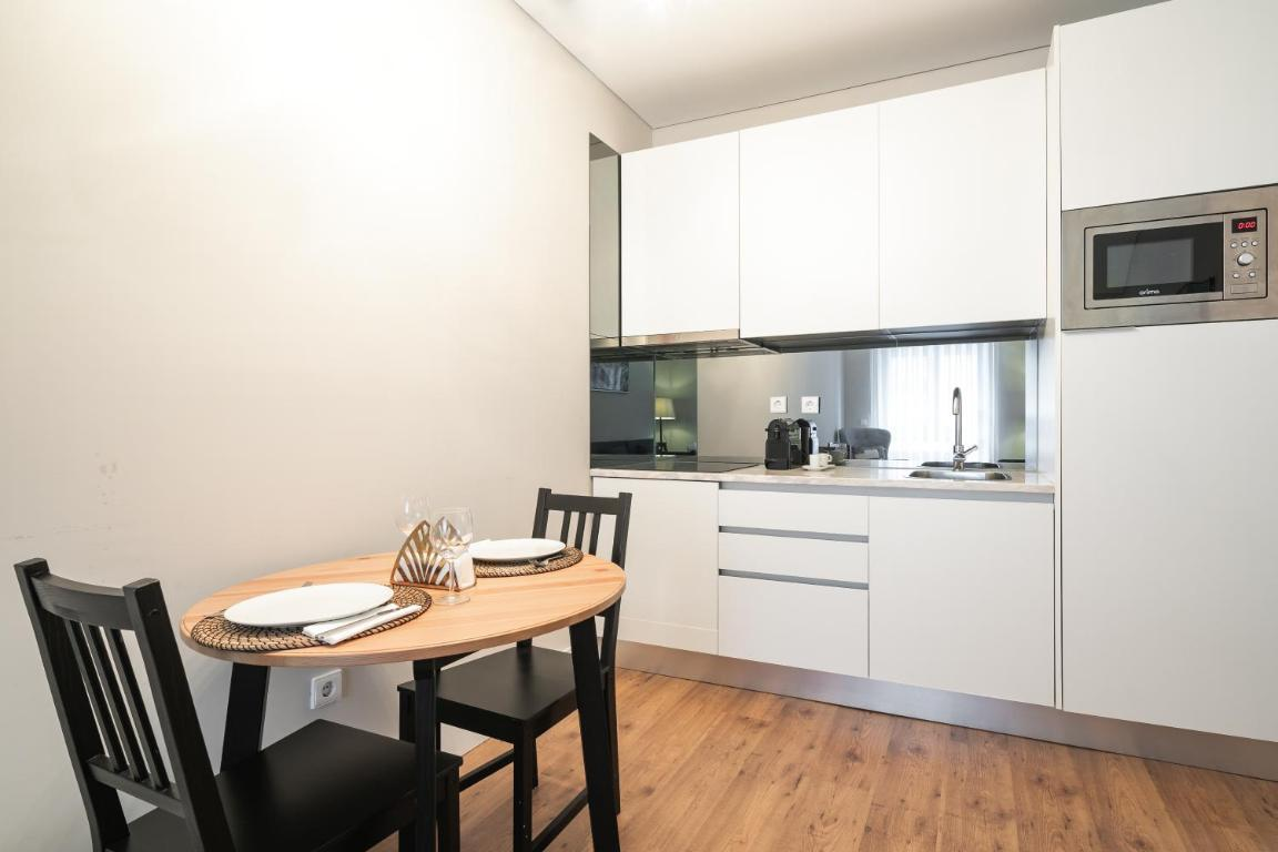 uma cozinha com uma mesa de madeira e duas cadeiras