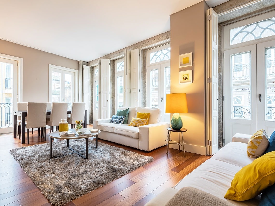 uma sala de estar com sofá branco e muitas janelas