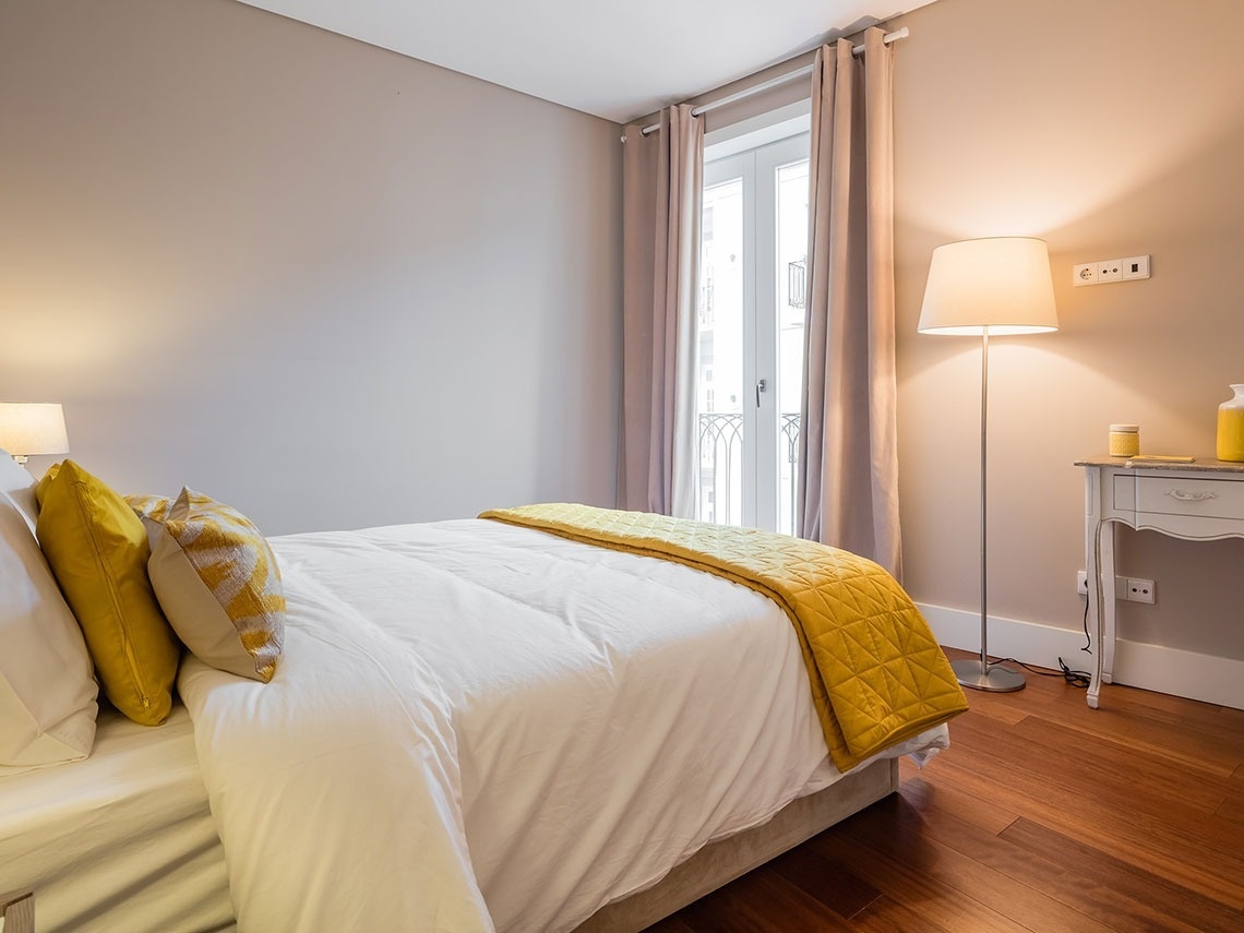 um quarto com cama , mesa e lâmpada