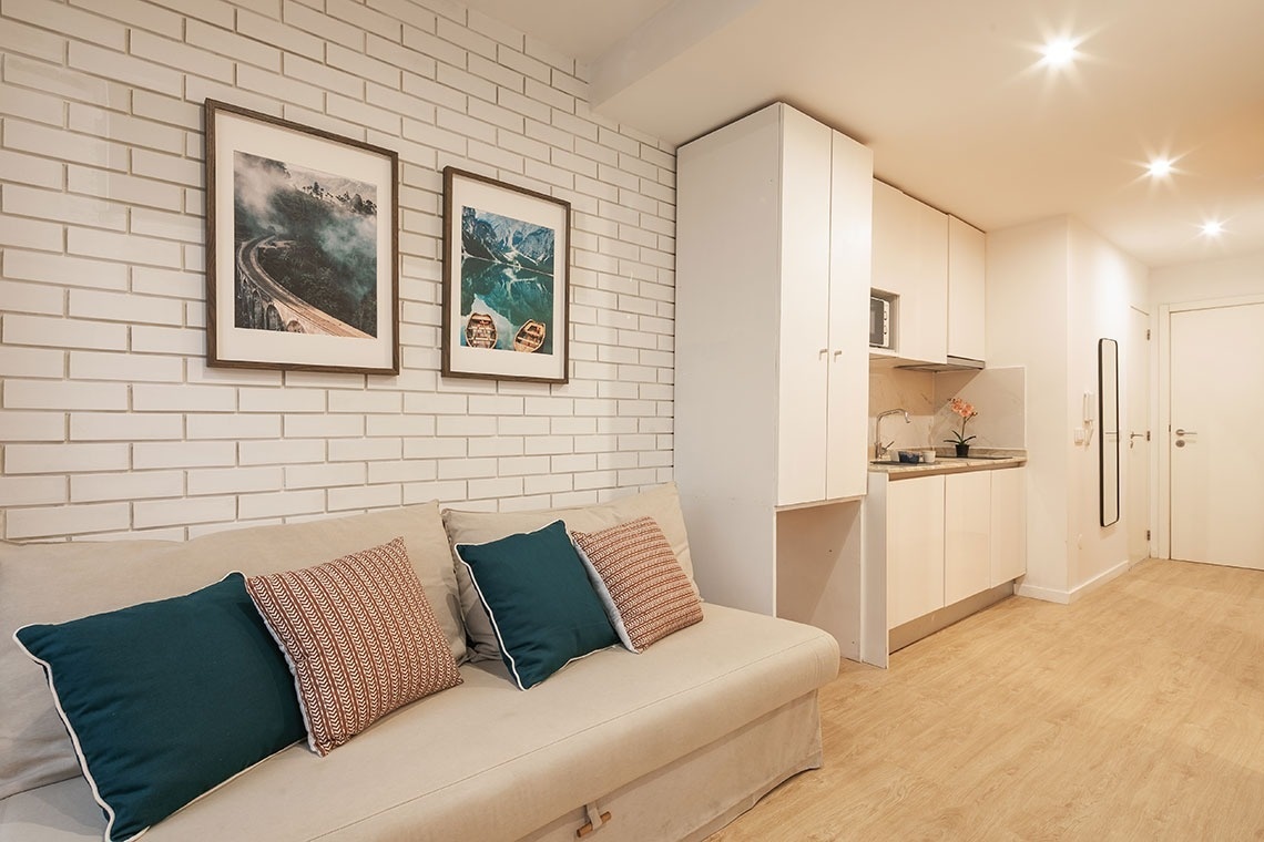 uma sala de estar com um sofá e dois quadros na parede