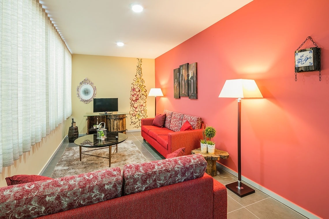 uma sala de estar com sofá vermelho e paredes vermelhas