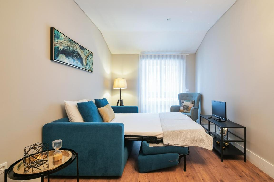 uma sala com um sofá azul e uma cadeira