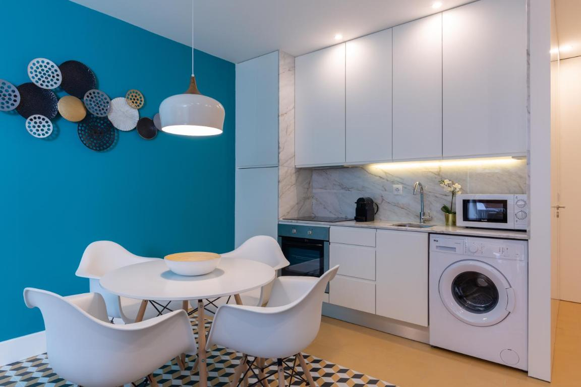 uma cozinha com parede azul e armários brancos