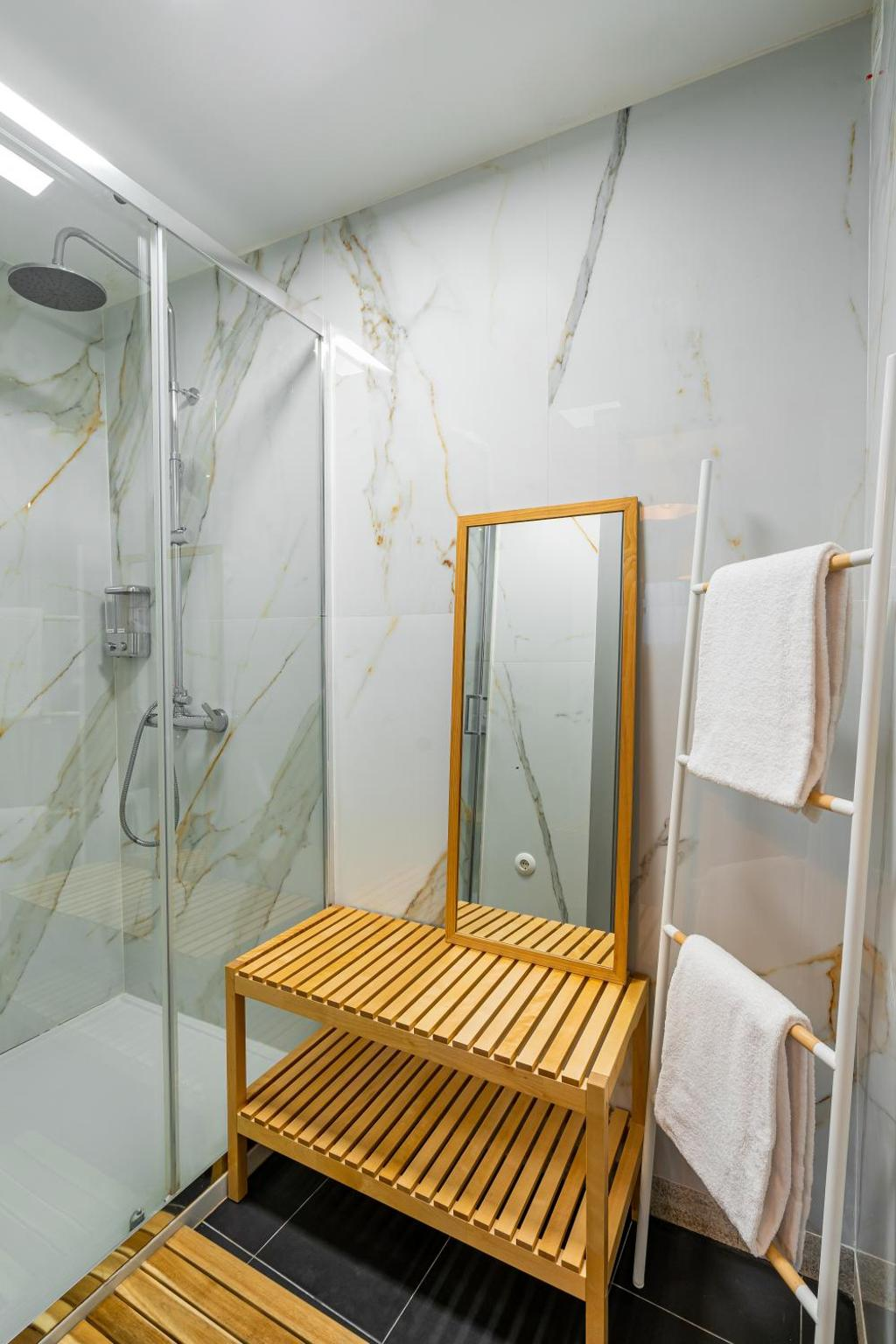 um banheiro com um chuveiro e um espelho