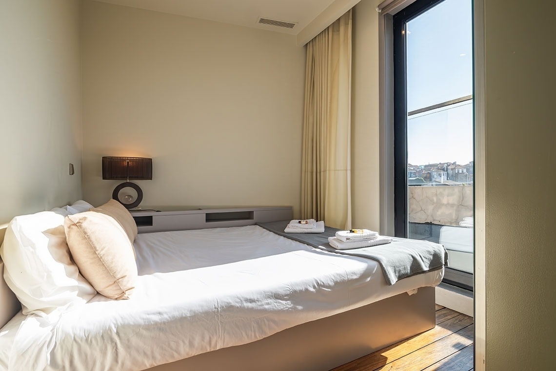 um quarto com uma cama e uma grande janela