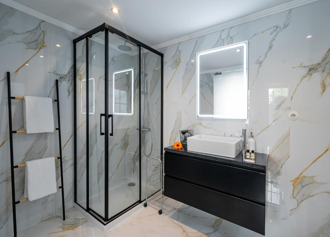 um banheiro com paredes de mármore e uma pia branca