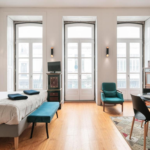 a room with a bed a chair a table and a tv