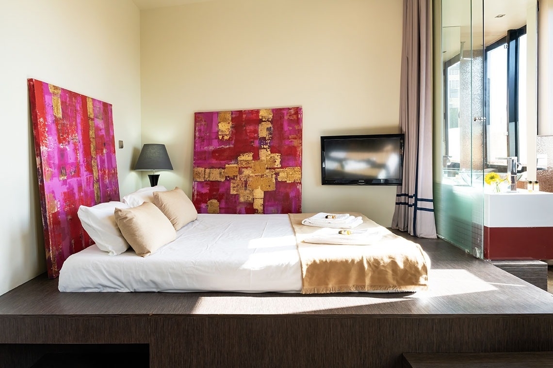 um quarto com uma cama e uma televisão na parede