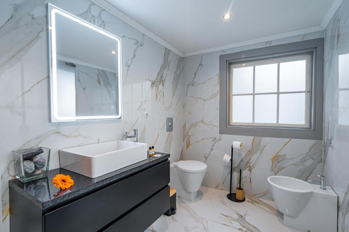 um banheiro com pia , vaso sanitário e espelho